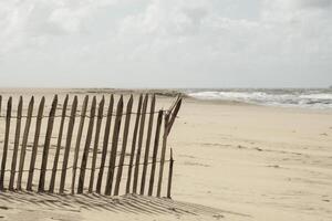 de madeira cerca em a arenoso de praia foto