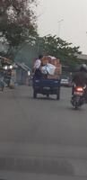 bekasi, Indonésia dentro Julho 2018. uma criança equitação em uma tossa motocicleta preenchidas com pilhas do cartão. foto