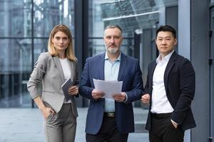 uma equipe do com experiência equipe líderes e especialistas, uma diverso grupo do o negócio pessoas, três pessoas dentro o negócio roupas estão sério e focado dentro o negócio roupas olhando às a Câmera foto