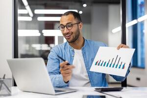 sorridente indiano homem de negocios dentro casual vestem segurando uma Barra gráfico relatório durante uma apresentação dentro uma moderno escritório contexto. foto