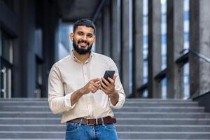 sorridente jovem profissional usando Smartphone em cidade escadas foto