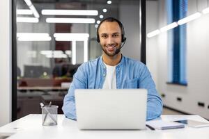 uma profissional homem de negocios atentamente trabalhando em dele computador portátil dentro uma contemporâneo escritório espaço, exibindo dedicação e eficiência. foto