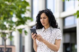 triste desapontado mulher recebido conectados notificação com mau notícia em dela telefone, empresária caminhando lado de fora escritório prédio, usando inscrição em Smartphone, lendo social meios de comunicação insatisfeito. foto