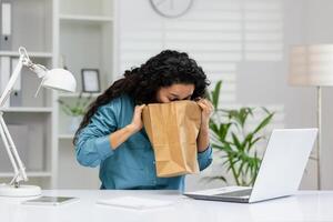 uma jovem mulher experiências de repente náusea às dela escritório mesa, possivelmente dentro precisar do médico atenção ou apoiar. foto