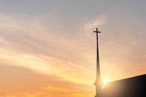 silhueta do a Cruz em a Igreja com borrado pôr do sol fundo foto