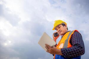 capataz trabalhador dentro capacetes em construção site, engenheiro homem verificação projeto às a infraestrutura local foto