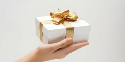 mão segurando branco presente caixa com ouro fita em branco fundo. produtos fotografia. foto