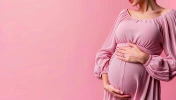 grávida mulher tocante dela barriga sobre Rosa fundo com cópia de espaço foto