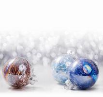enfeites de Natal de prata e azul em fundo de bokeh de brilho com espaço para texto. natal e feliz ano novo foto