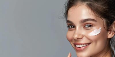 jovem mulher com Cosmético creme em dela face pele Cuidado foto