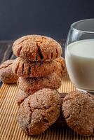 caloroso caseiro gingersnap biscoitos cinzento toalha e leite foto