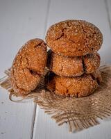 caloroso caseiro gingersnap biscoitos em uma de madeira borda foto