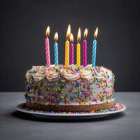 colorida aniversário bolo com granulados e velas em uma azul cinzento fundo. foto