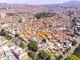 paisagem urbana do principal estradas entre denso residencial áreas dentro Bandung cidade. Visão do a denso residencial e rodovias dentro cidade baixa. social problemas. zangão fotografia. tiro a partir de uma zangão vôo 100 metros foto