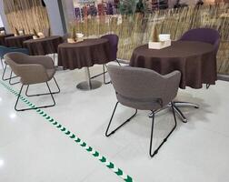 cafeteria dentro a lobby do a supermercado mesas com Castanho toalhas de mesa e estofado cadeiras. foto