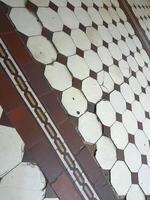 velho cerâmico azulejos em a chão. Antiguidade chão azulejos foto