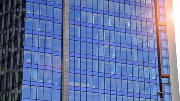 vidro construção com transparente fachada do a construção e azul céu. estrutural vidro parede refletindo azul céu. abstrato moderno arquitetura fragmento. contemporâneo arquitetônico fundo. foto