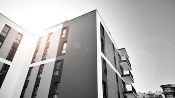 fragmento do a edifício de fachada com janelas e varandas. moderno apartamento edifícios em uma ensolarado dia. fachada do uma moderno residencial prédio. Preto e branco. foto