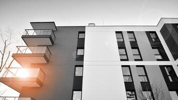 fragmento do a edifício de fachada com janelas e varandas. moderno apartamento edifícios em uma ensolarado dia. fachada do uma moderno residencial prédio. Preto e branco. foto