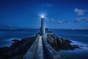 ampla retro farol com viga do brilhante luz brilhando Fora para azul mar foto