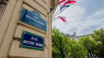 francês tricolor bandeiras onda acima a arruda Aristide briand placa em uma ensolarado Primavera dia dentro Paris, França, simbolizando nacional orgulho, tiro em abril 14, 2024 foto