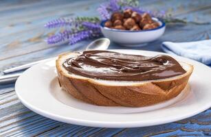 espalhando avelã creme em pão, chocolate noz manteiga foto