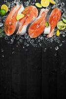 salmão bifes em gelo em Preto de madeira mesa foto