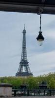 icônico eiffel torre dentro Paris, França, emoldurado de uma rua luminária com Primavera folhagem, capturado em abril 14, 2024, perfeito para viagem e europeu feriados temas foto