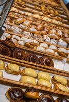 uma muitos do doce pastelaria dentro cestas em a contador dentro a Comida loja. padaria em a bufê mesa. o negócio café da manhã e refeições às eventos. vários pão tipo em prateleira. fechar-se. seletivo foco. foto