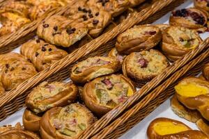 uma muitos do doce pastelaria dentro cestas em a contador dentro a Comida loja. padaria em a bufê mesa. o negócio café da manhã e refeições às eventos. vários pão tipo em prateleira. fechar-se. seletivo foco. foto