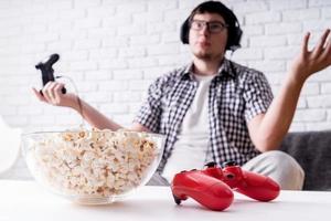 jovem desapontado jogando videogame em casa foto