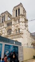 restauração dentro progresso às notre dame catedral com turistas dentro Paris, França, em abril 14, 2024, simbolizando cultural herança e europeu viagem destinos foto