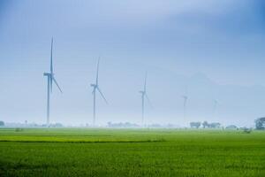 Visão do turbina verde energia eletricidade, moinho de vento para elétrico poder Produção, vento turbinas gerando eletricidade em arroz campo às phan tocou, ninh thuan província, Vietnã foto