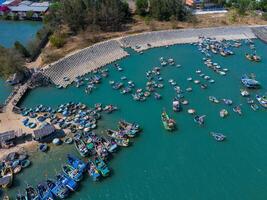 aéreo Visão do loc a pescaria Vila, Vung tau cidade. uma pescaria porta com tsunami proteção concreto blocos. paisagem urbana e tradicional barcos dentro a mar. foto