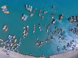 aéreo Visão do loc a pescaria Vila, Vung tau cidade. uma pescaria porta com tsunami proteção concreto blocos. paisagem urbana e tradicional barcos dentro a mar. foto