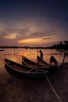 tradicional barcos às o empréstimo lagoa dentro pôr do sol, phu iene província, Vietnã foto