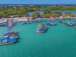 aéreo Visão do loc a pescaria Vila, Vung tau cidade. uma pescaria porta com tsunami proteção concreto blocos. paisagem urbana e tradicional barcos dentro a mar. foto