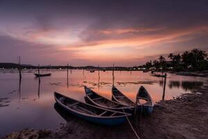 tradicional barcos às o empréstimo lagoa dentro pôr do sol, phu iene província, Vietnã foto