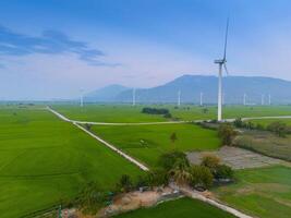 Visão do turbina verde energia eletricidade, moinho de vento para elétrico poder Produção, vento turbinas gerando eletricidade em arroz campo às phan tocou, ninh thuan província, Vietnã foto