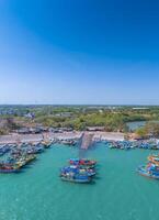 aéreo Visão do loc a pescaria Vila, Vung tau cidade. uma pescaria porta com tsunami proteção concreto blocos. paisagem urbana e tradicional barcos dentro a mar. foto