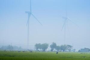 Visão do turbina verde energia eletricidade, moinho de vento para elétrico poder Produção, vento turbinas gerando eletricidade em arroz campo às phan tocou, ninh thuan província, Vietnã foto