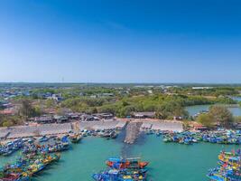 aéreo Visão do loc a pescaria Vila, Vung tau cidade. uma pescaria porta com tsunami proteção concreto blocos. paisagem urbana e tradicional barcos dentro a mar. foto