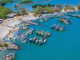 aéreo Visão do loc a pescaria Vila, Vung tau cidade. uma pescaria porta com tsunami proteção concreto blocos. paisagem urbana e tradicional barcos dentro a mar. foto