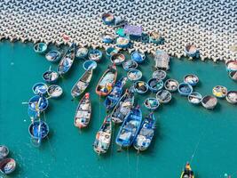 aéreo Visão do loc a pescaria Vila, Vung tau cidade. uma pescaria porta com tsunami proteção concreto blocos. paisagem urbana e tradicional barcos dentro a mar. foto