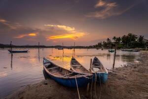 tradicional barcos às o empréstimo lagoa dentro pôr do sol, phu iene província, Vietnã foto