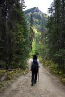mulher caminhante caminhando através a rochoso montanhas do Canadá. foto