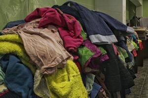 humanitário ajuda Centro do Apoio, suporte e Socorro pobre, refugiado e sem teto pessoas. parcimonioso loja. circular moda, doação, caridade. vintage roupas fazer compras foto