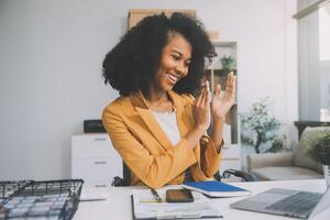 foto do bonita jovem menina sentar Área de Trabalho pc aguarde caneta escrever bloco de anotações vestem óculos camisa dentro casa escritório dentro de casa