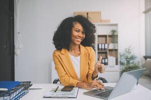 empresária asiática usando computador portátil e trabalhando no escritório com documento de calculadora na mesa, fazendo planejamento analisando o relatório financeiro, investimento em plano de negócios, conceito de análise financeira. foto