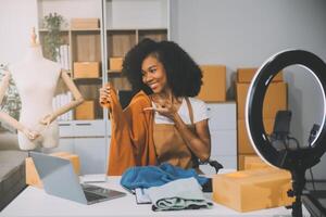 moda blogueiro conceito, jovem ásia mulheres vendendo roupas em streaming.startup pequeno o negócio sme, usando Smartphone ou tábua levando receber e verificação dentro escritório foto